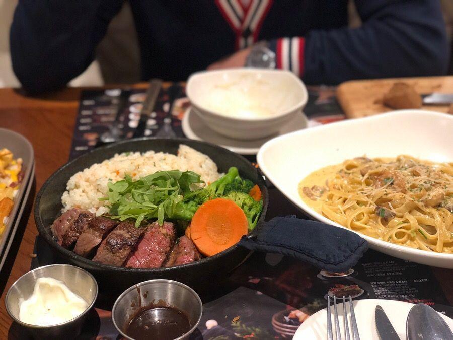 高速巴士转运站Outback Steakhouse美味餐点组合，包含牛排米饭与奶油意大利面，是一次豪华的用餐体验。